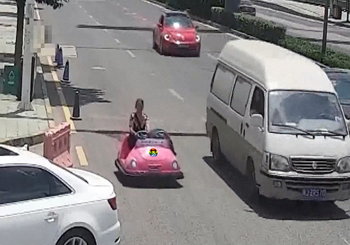 HD Mulher conduz carrinho de choque numa rua.jpg