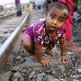 Bebé brinca caminho ferro em Daca, Bangladesh